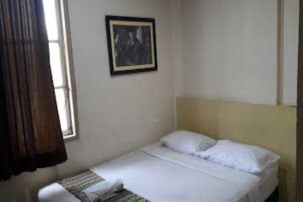 1 dormitorio con 2 camas y una foto en la pared en EXPRESS O 91674 Penginapan Bm Prima, en Duri