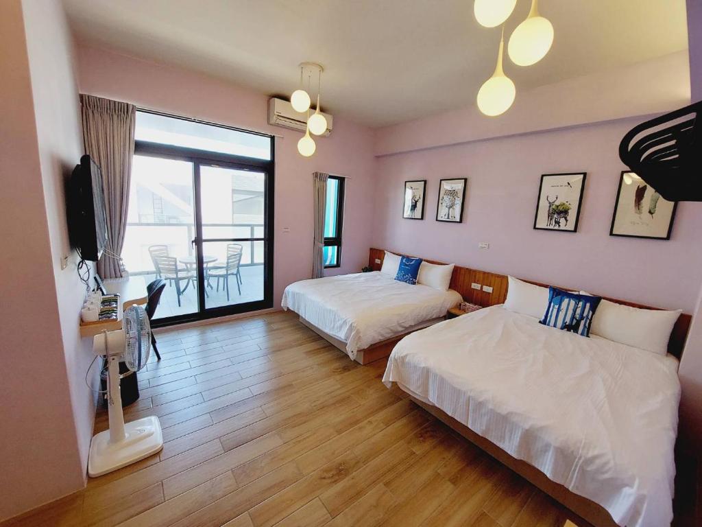 ein Hotelzimmer mit 2 Betten und einem Balkon in der Unterkunft Summer Dream in Magong