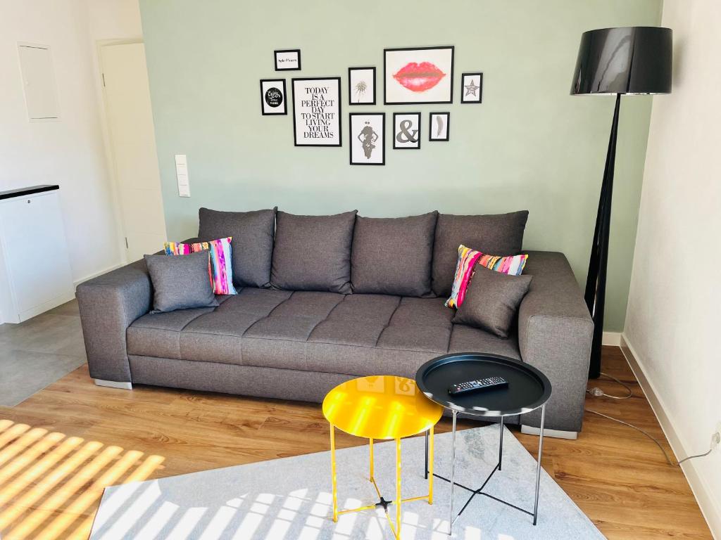 a living room with a gray couch and a table at Ferienwohnung EnsheimLiebe in Saarbrücken