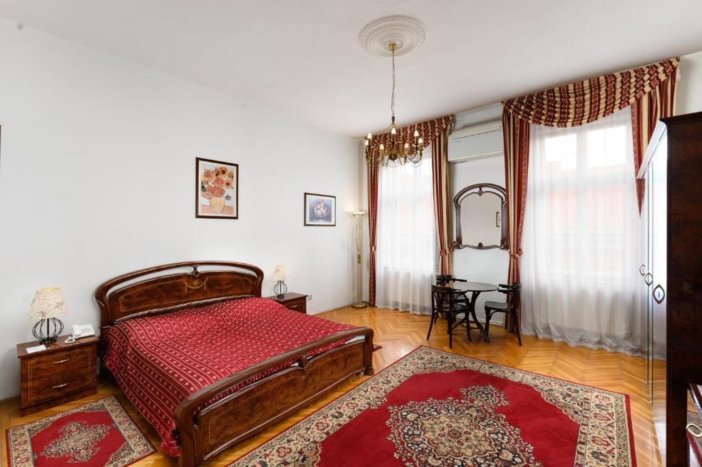 Kalvin House Budapest في بودابست: غرفة نوم فيها سرير وطاولة فيها