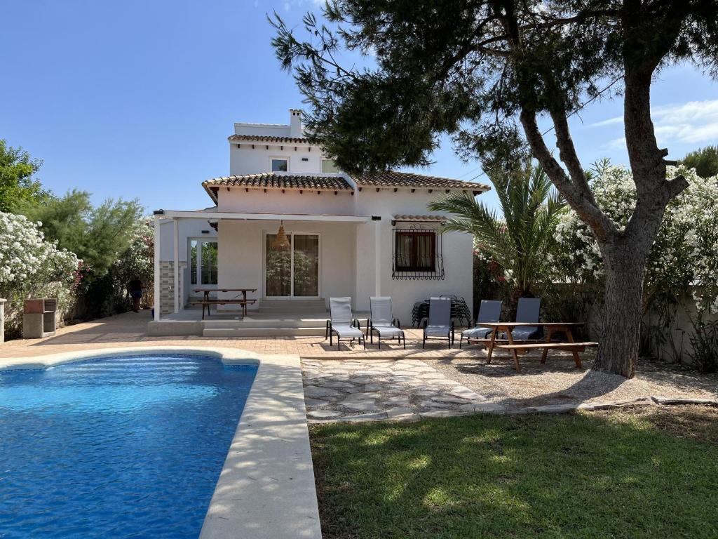 a villa with a swimming pool in front of a house at Montenegro - BTB in Denia