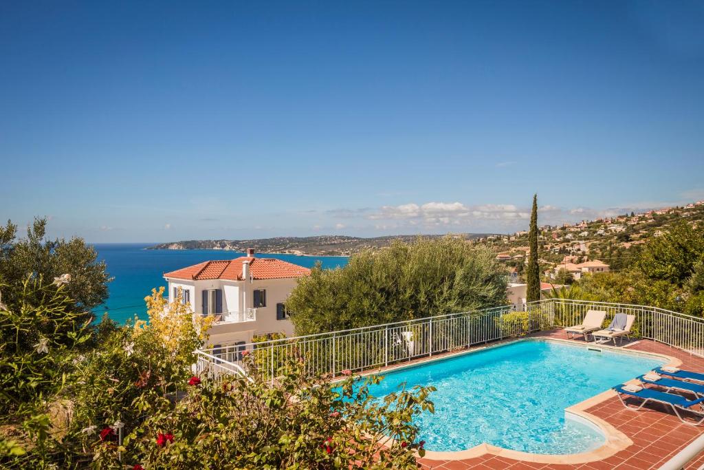 a villa with a swimming pool and a view of the ocean at Rhakotis Villa in Lourdhata