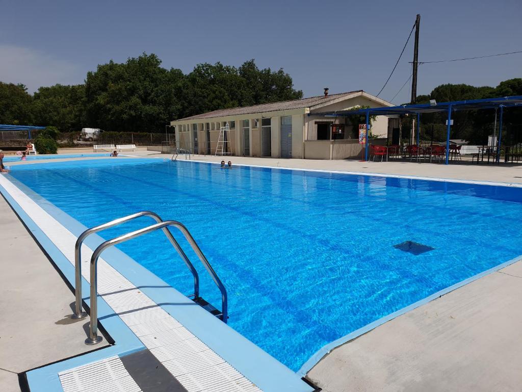 a large swimming pool with blue water at CAMPING LE BEL AIR Mobil home L&#39;OLIVIER 4 personnes in Limogne-en-Quercy