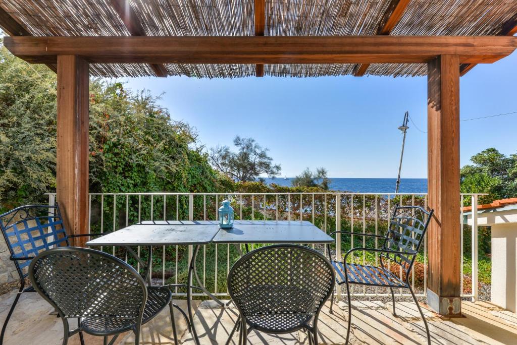 a table and chairs on a deck with a view of the ocean at Il Quartiere apt Giglio in Pomonte