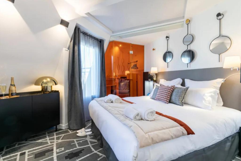a bedroom with a large bed with towels on it at Sublim by Sweet Inn in Paris
