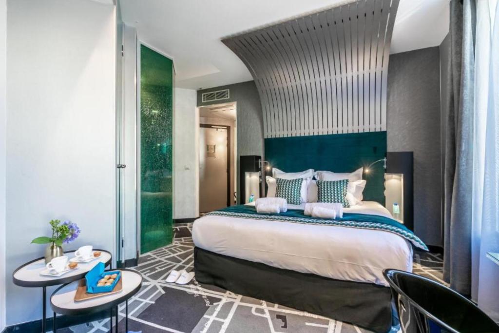 - une chambre avec un grand lit et un mur vert dans l'établissement Sublim by Sweet Inn, à Paris