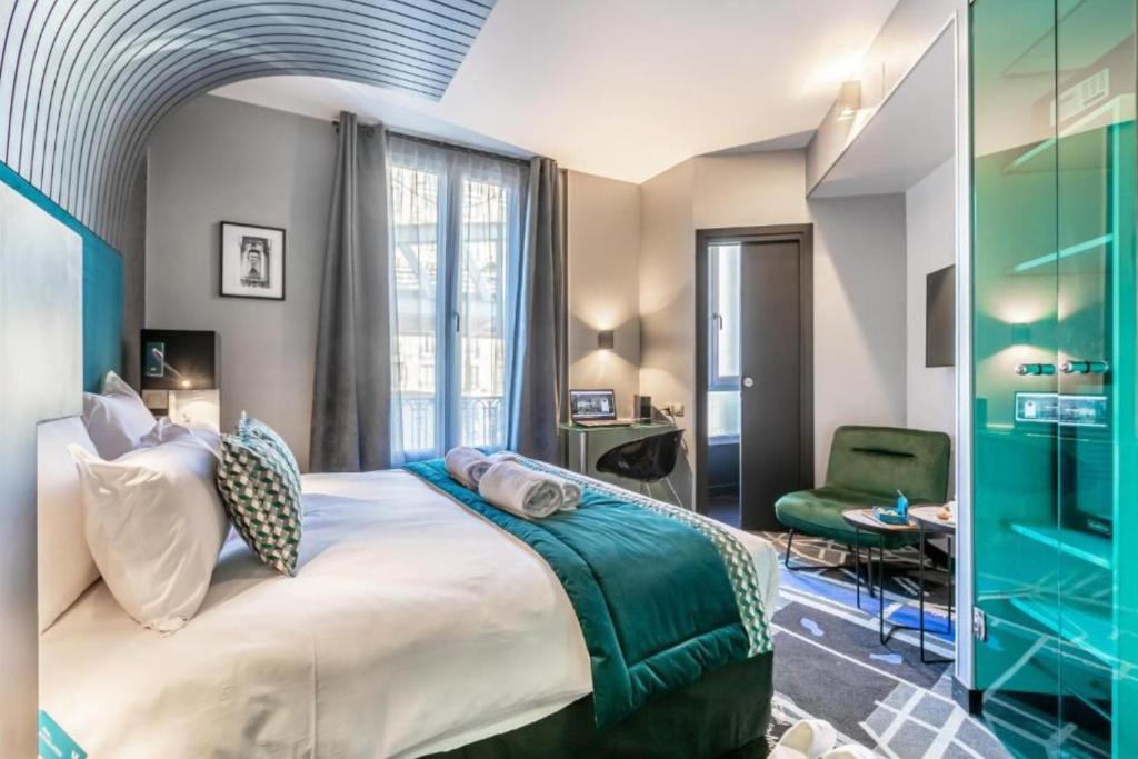 a bedroom with a large bed and a green chair at Sublim by Sweet Inn in Paris