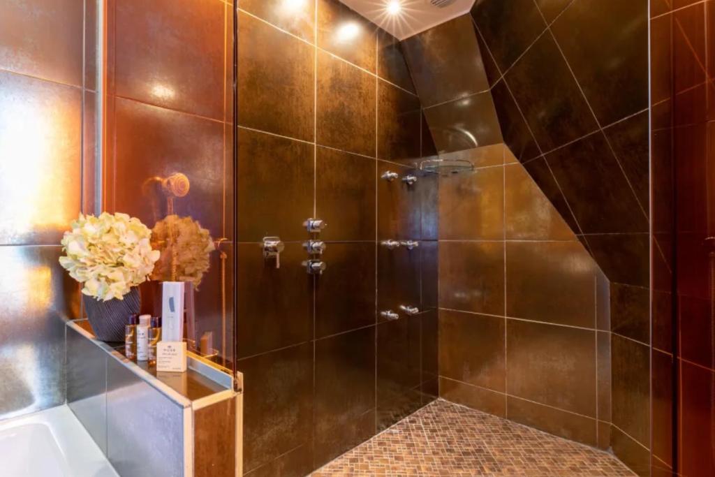 a shower with a glass door in a bathroom at Sublim by Sweet Inn in Paris