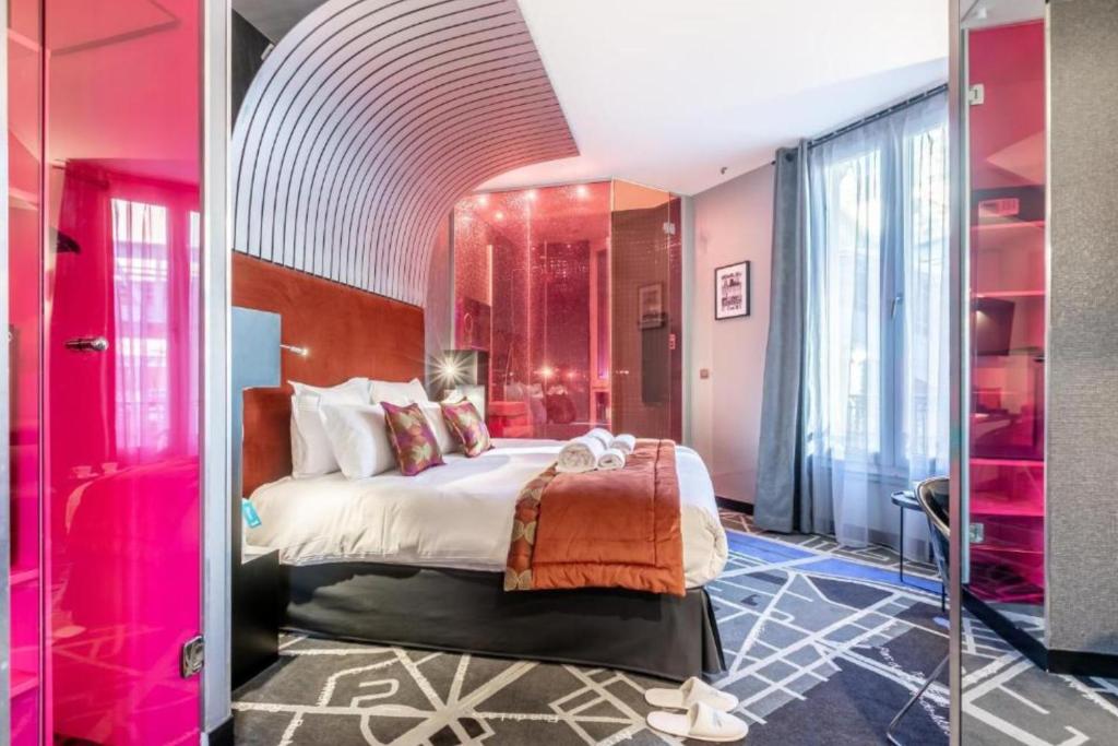 a bedroom with a large bed with pink walls at Sublim by Sweet Inn in Paris