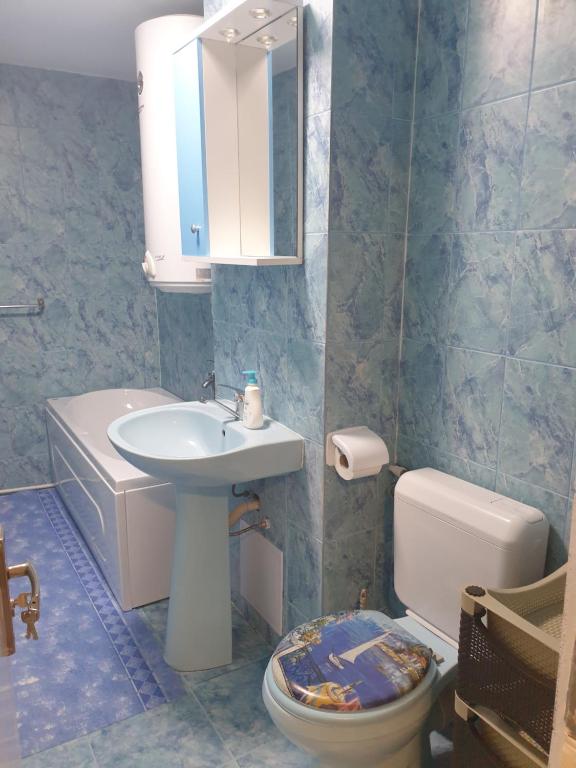 ein Badezimmer mit einem Waschbecken, einem WC und einem Spiegel in der Unterkunft RazDav Straja Central in Lupeni