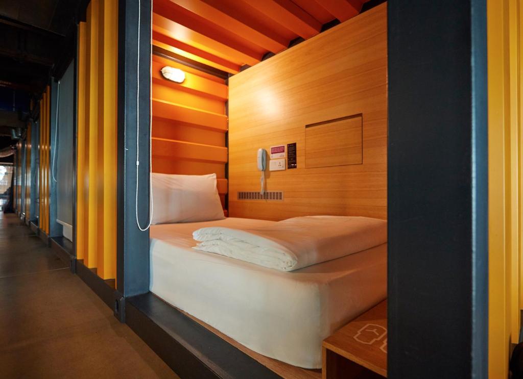 una piccola camera da letto con un letto in una stanza di CapsuleTransit Landside - Airport Hotel - Public Area - Gateway KLIA T2, Lvl 1 a Sepang
