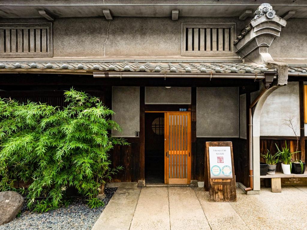 een toegang tot een gebouw met een houten deur bij Udatsuya in Osaka