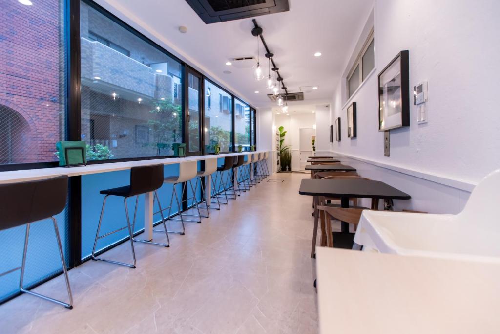 a bar in a restaurant with a row of stools at Asakusa Designer Hotel YOSHII in Tokyo