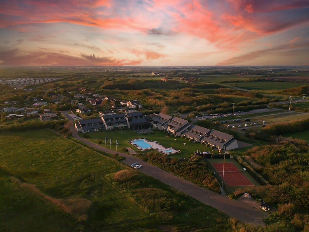 an aerial view of a house with a tennis court at Fletcher Zuiderduin Beachhotel in Westkapelle