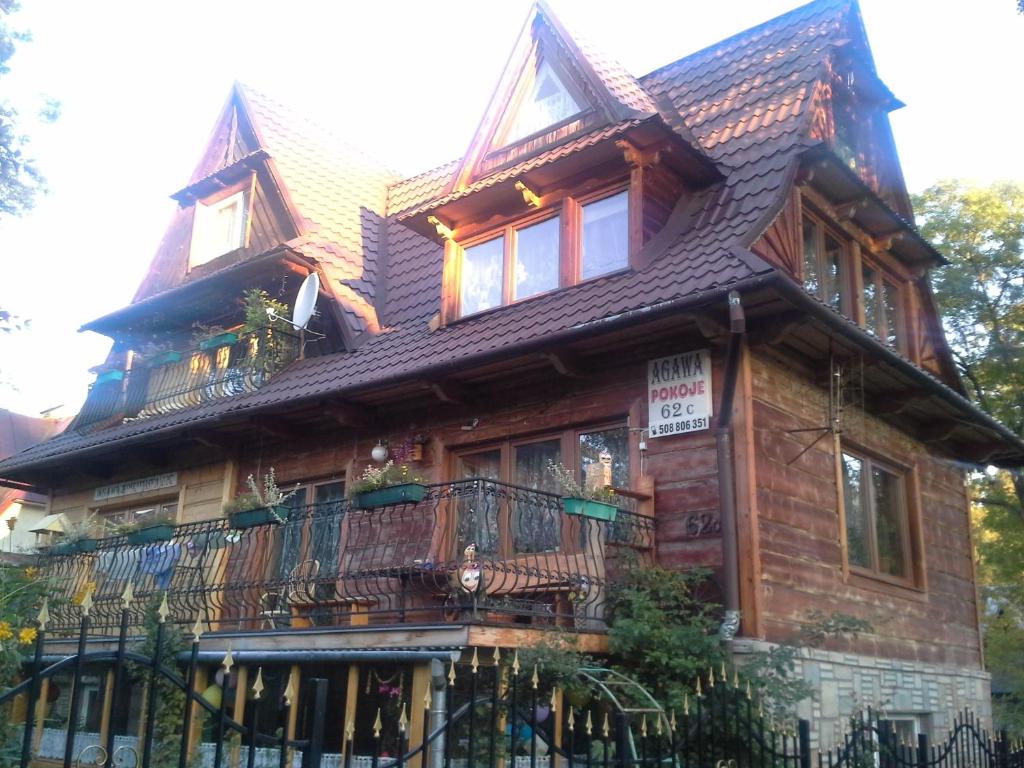 a large wooden house with a balcony at Agawa in Zakopane
