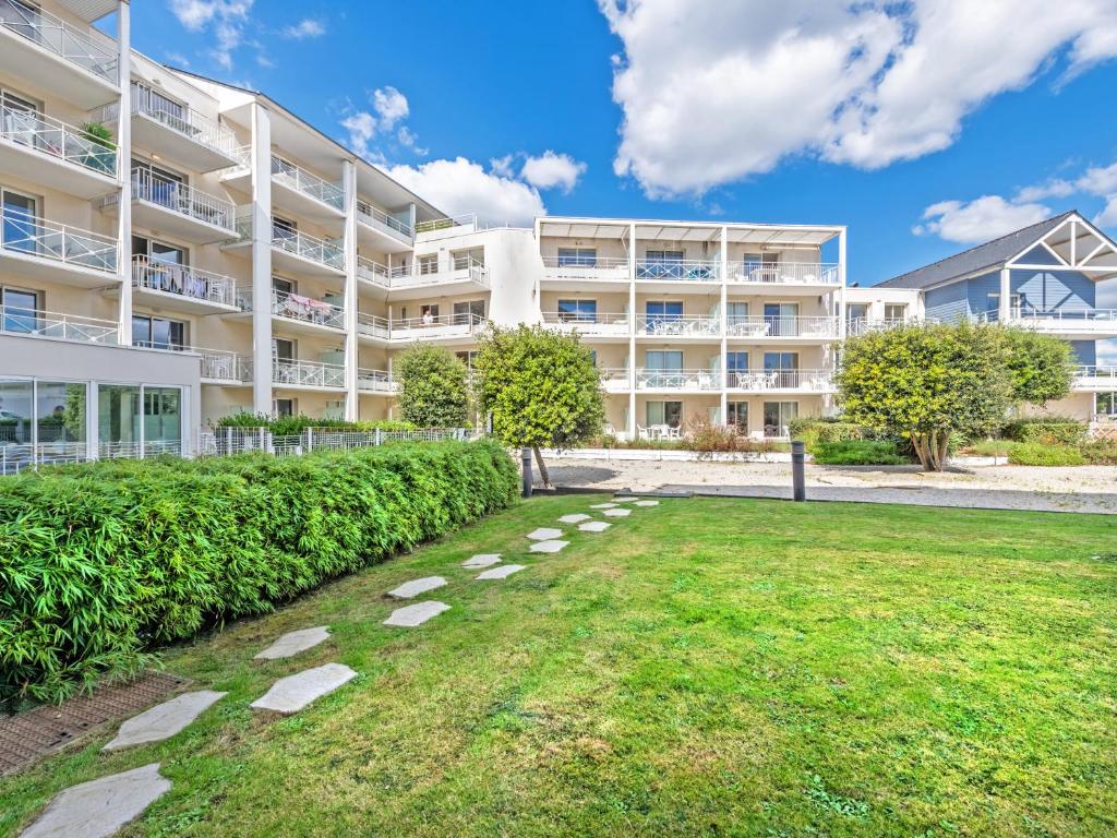 プルゴンヴランにあるVacancéole - Le Domaine de Bertheaumeの芝生の前に建つ大きなアパートメントです。