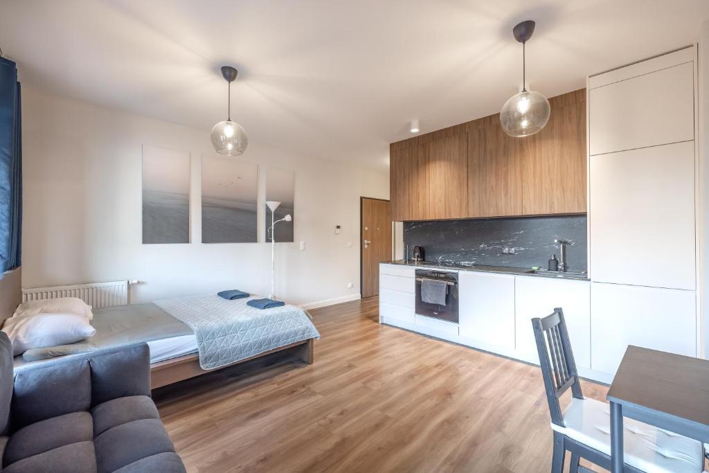 a bedroom with a bed and a couch and a table at Apartament z balkonem blisko Starego Miasta in Gdańsk