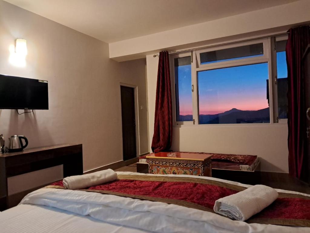 a hotel room with a bed and a window at The Sherpa's Abode in Gangtok