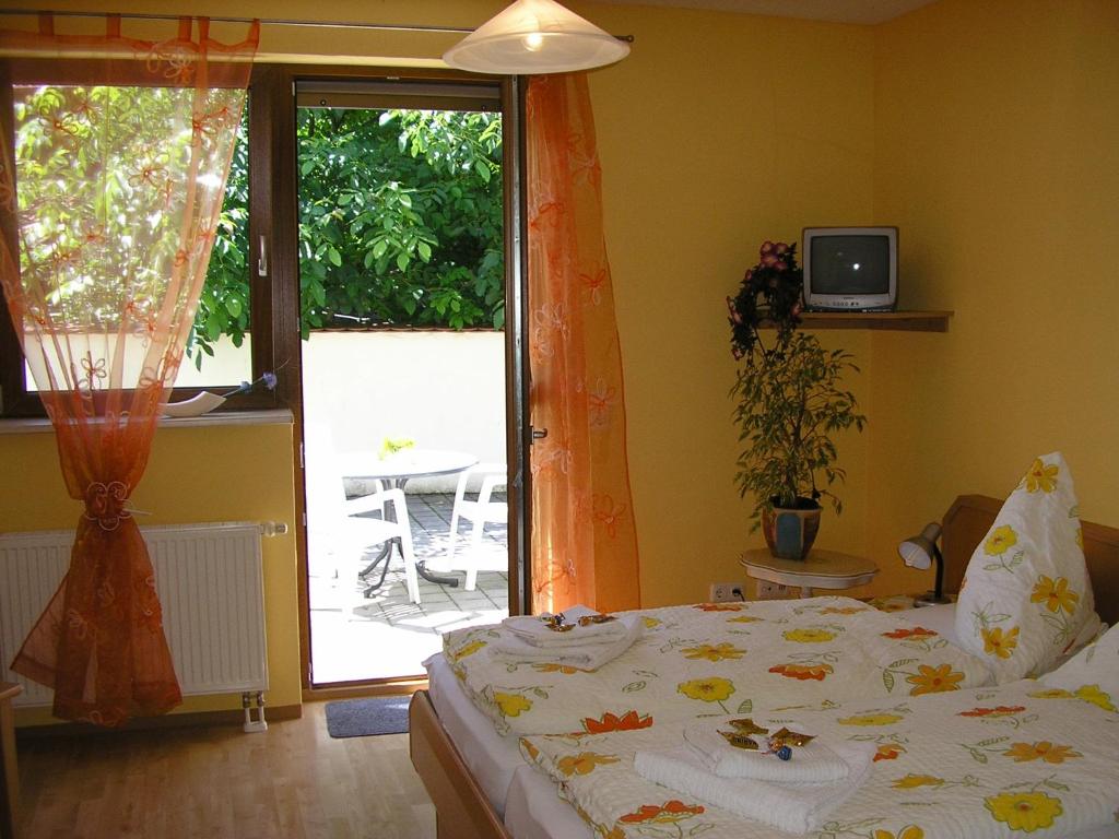 a bedroom with a bed and a sliding glass door at Pension Lindenallee in Neuendettelsau