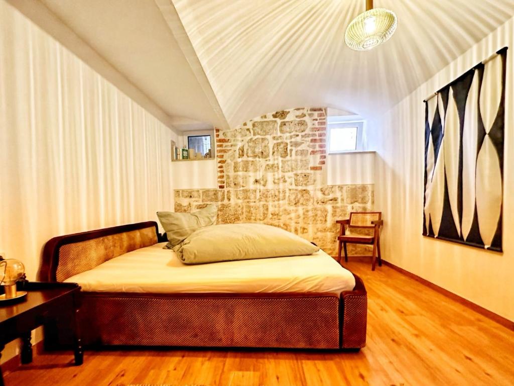 1 dormitorio con cama y pared de piedra en RÖSCH Apartment, en Weimar