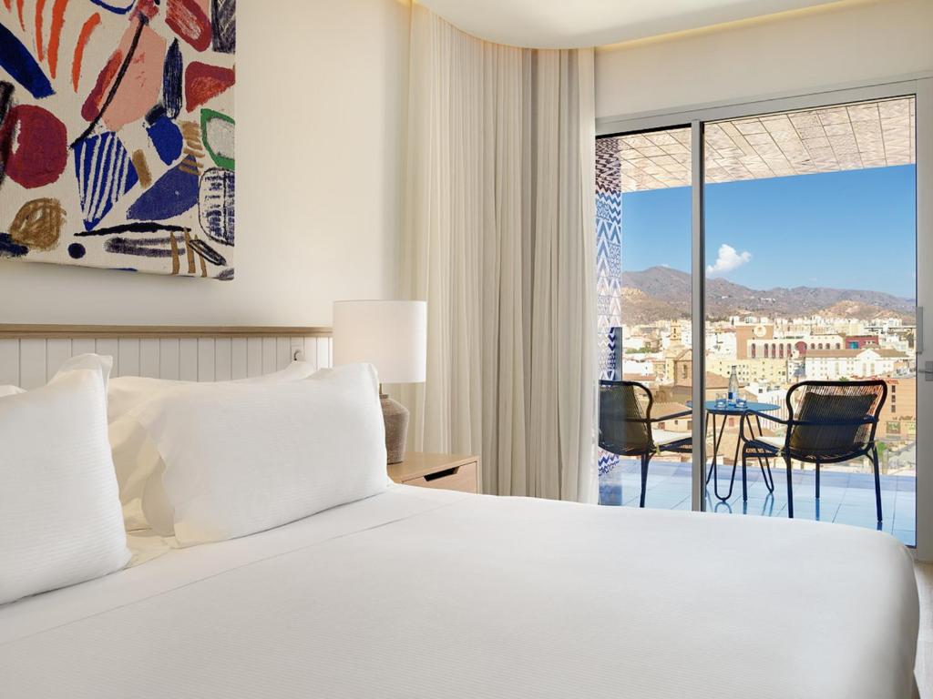 Łóżko lub łóżka w pokoju w obiekcie H10 Croma Málaga