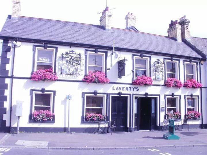 a white building with flowers on the front of it at Laverty's - The Black Bull Inn in Randalstown