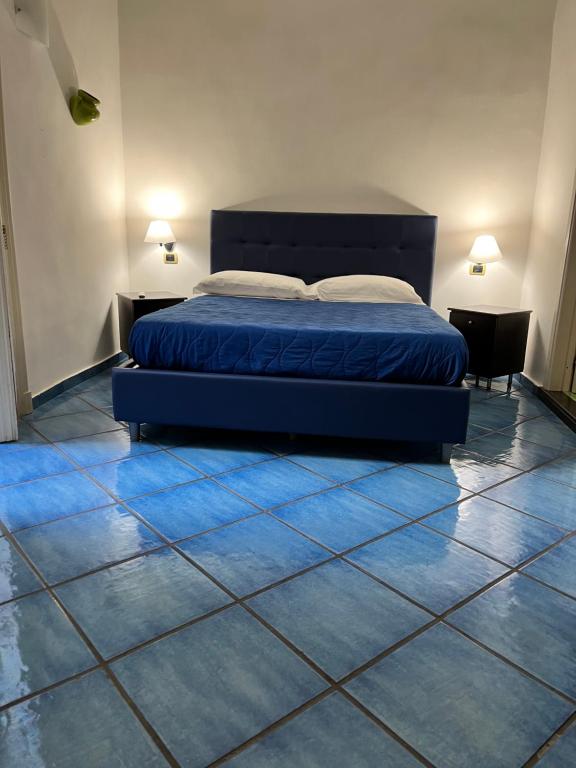 1 dormitorio con 1 cama azul y suelo de baldosa en B&B Riviera, en Nápoles