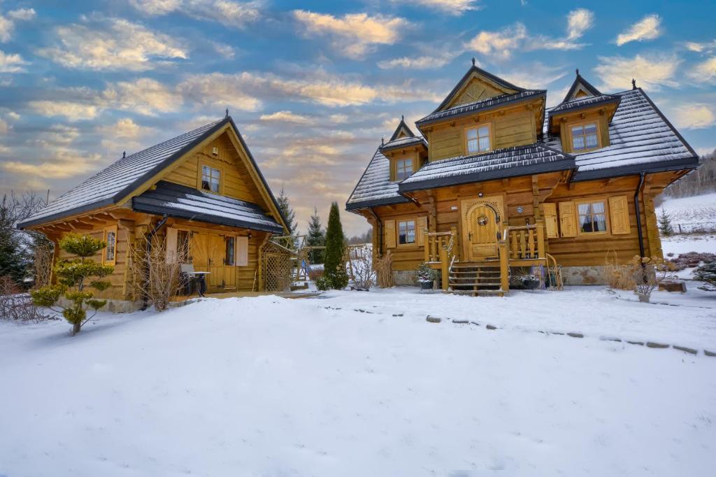 a large wooden house in the snow with snow at Dom Rajka in Stronie Śląskie