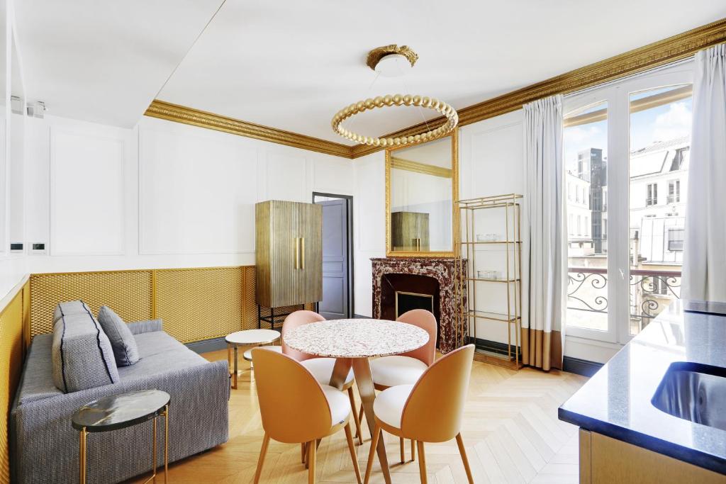 a living room with a couch and a table and chairs at Pick A Flat's Apartments in Champs Elysées - Rue du Colisée in Paris