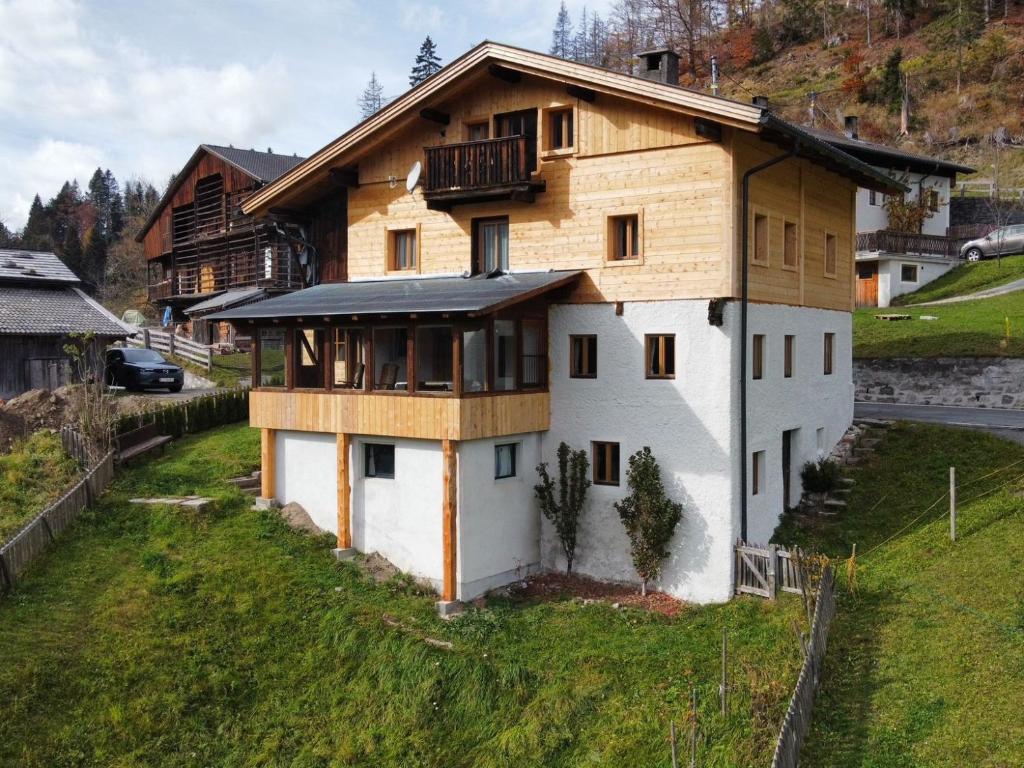 dom z drewnianym dachem na wzgórzu w obiekcie Ferienhaus "Schneider" w mieście Maria Luggau