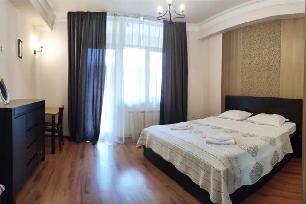 a bedroom with a large bed and a window at 1 bedroom unit with patio in Tbilisi City