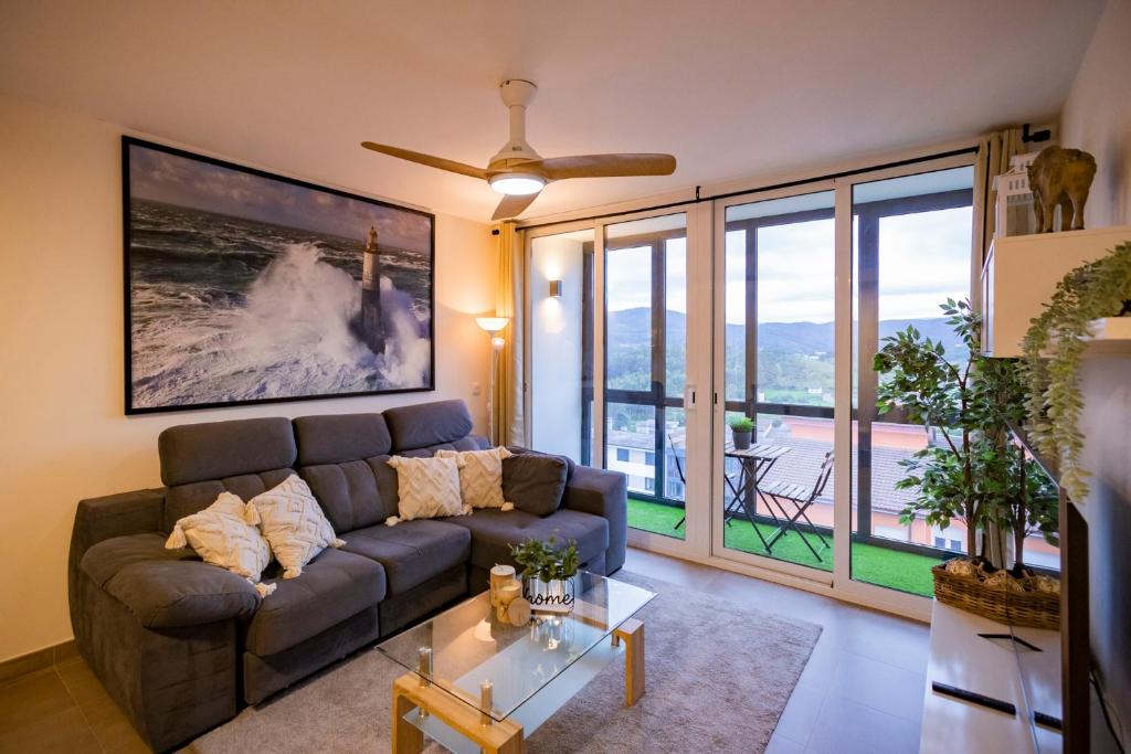 uma sala de estar com um sofá e uma grande janela em Area Suites em Jove