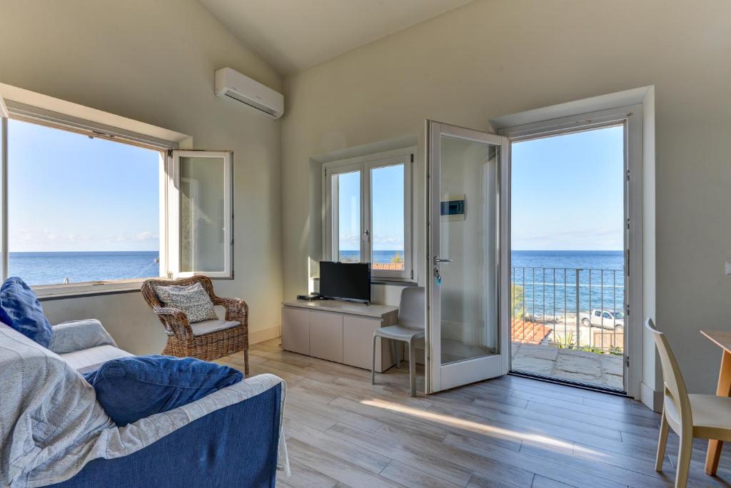 a living room with a view of the ocean at Il Quartiere apt Montecristo in Pomonte