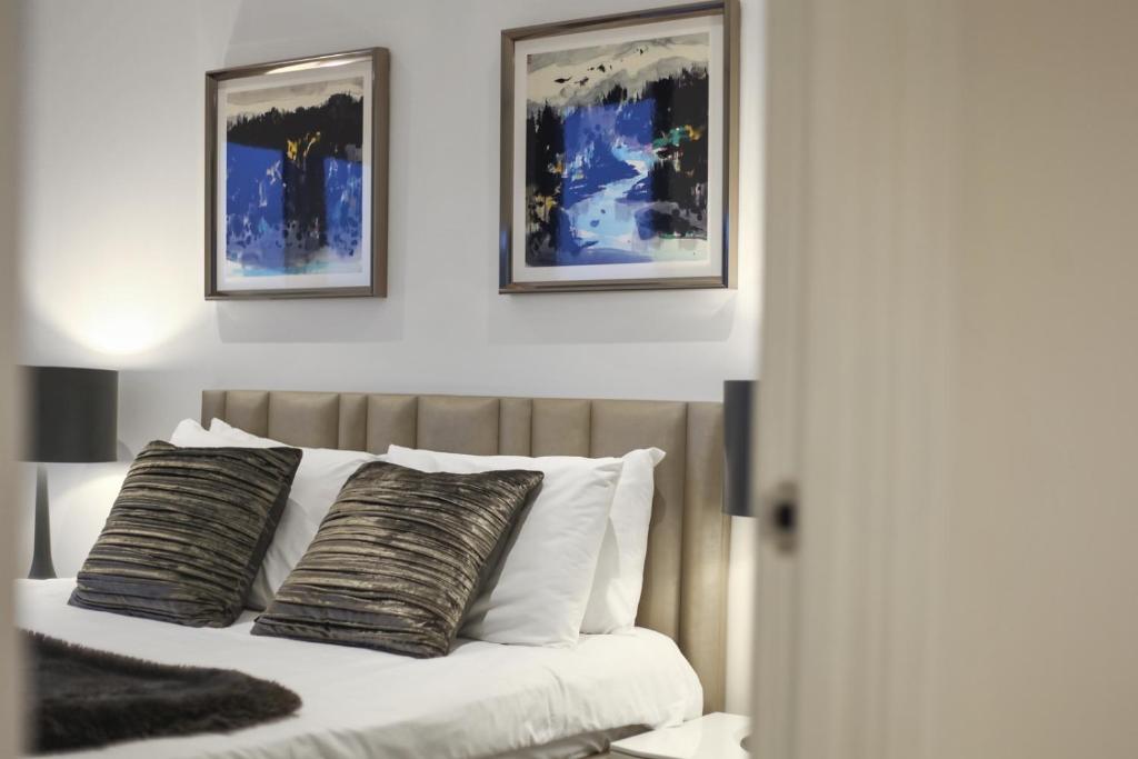 um quarto com uma cama com duas fotografias na parede em Lux Apartments next to Oxford Circus FREE WIFI & AIRCON by City Stay Aparts London em Londres