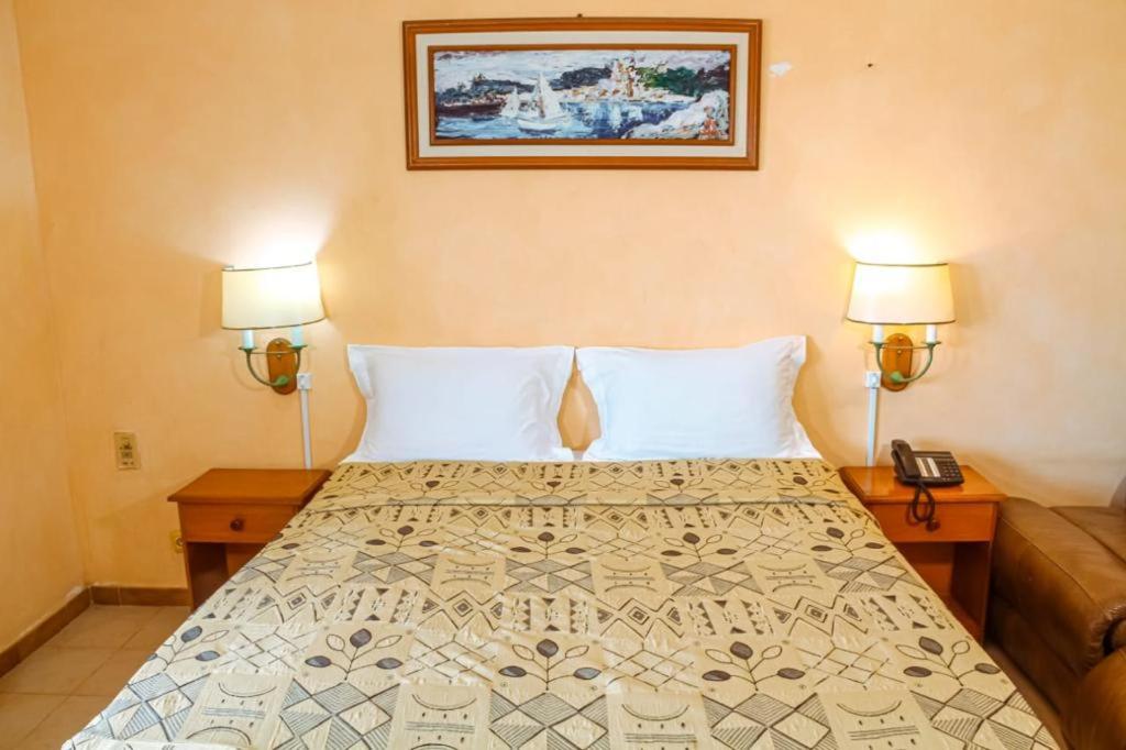 Ліжко або ліжка в номері Hôtel La Palmeraie Saint Louis Sénégal
