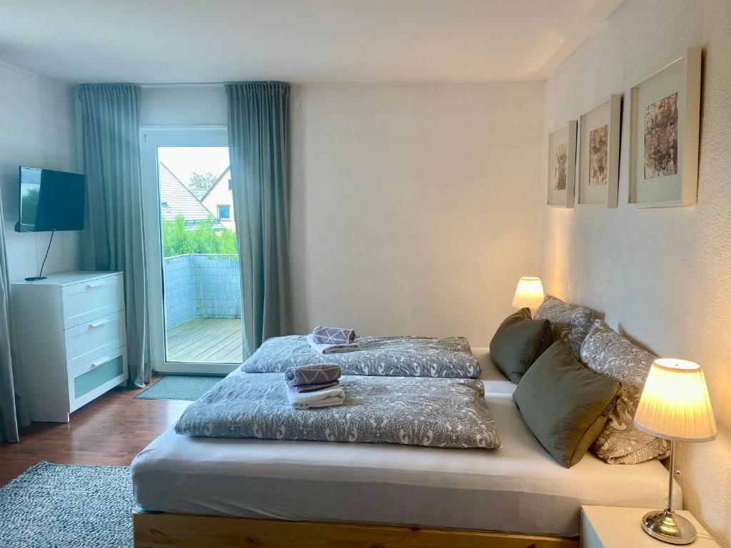 een slaapkamer met een bed en een glazen schuifdeur bij Allgäulodge Memmingen in Memmingen