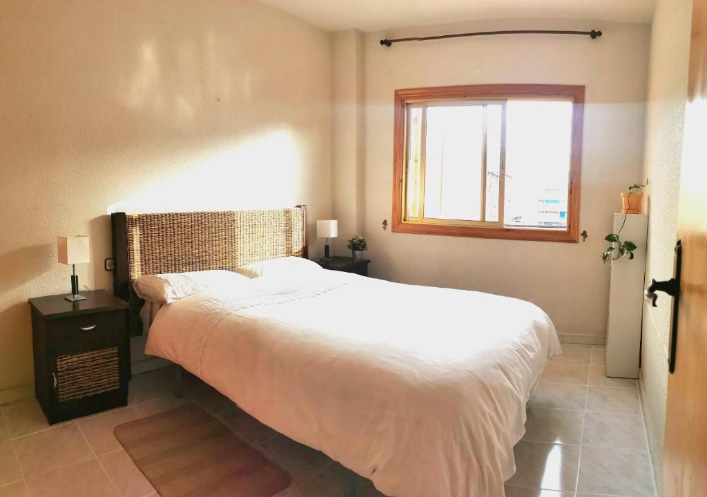 a bedroom with a large white bed and a window at Piso acogedor muy bien situado en Puerto Mazarrón in Puerto de Mazarrón