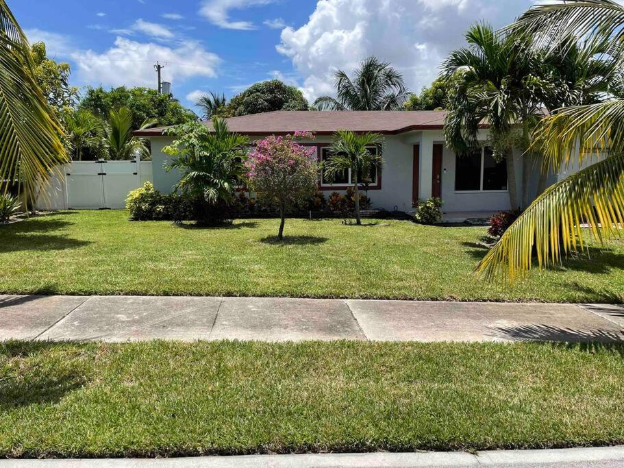 a house with a green yard with palm trees at Beautiful, quiet & cozy home near Lake Worth Beach in Lake Worth