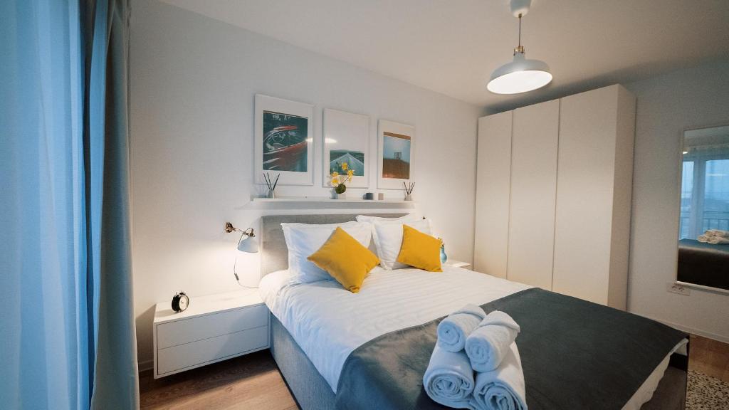 1 dormitorio con 1 cama con almohadas azules y amarillas en Sweet memories Apart Coresi 2, en Brasov