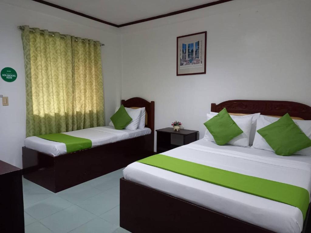 two beds in a room with green and white at Bans Beach Resort in Boracay