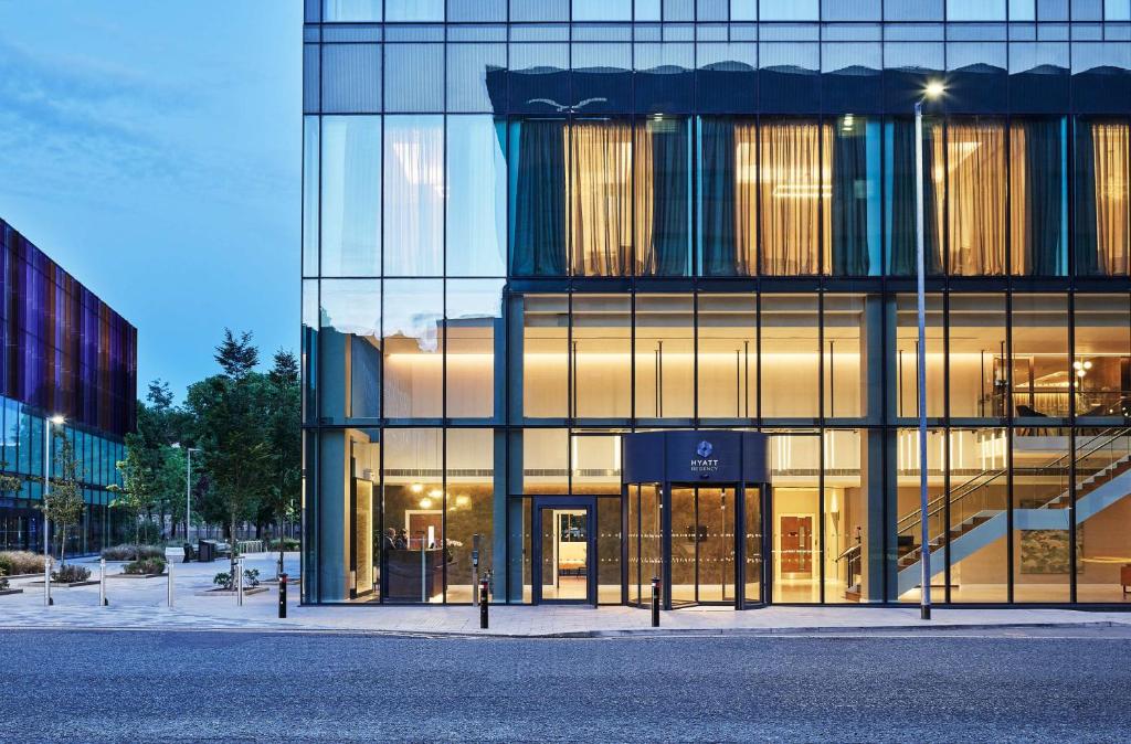 a large building with glass windows on a city street at Hyatt Regency Manchester in Manchester