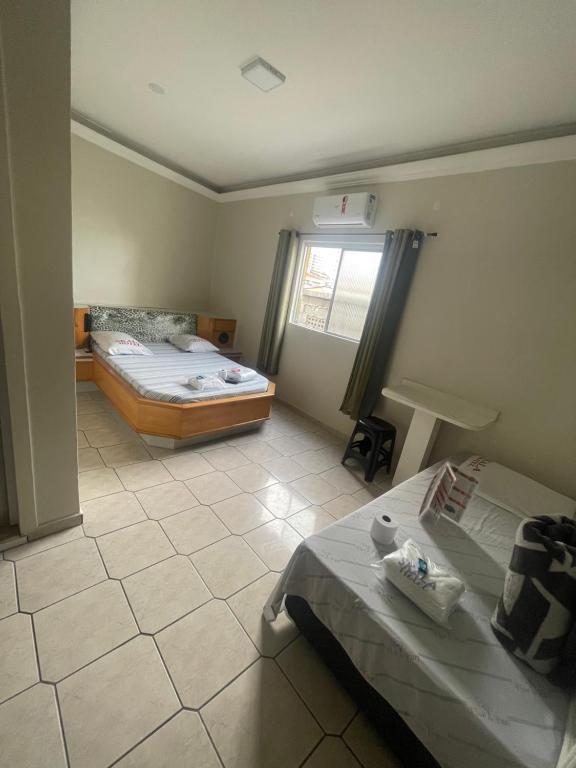 Cette petite chambre comprend 2 lits et une fenêtre. dans l'établissement HOTEL SKALA, à São Paulo