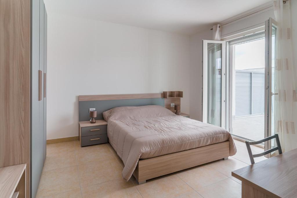 a bedroom with a bed and a large window at GuestHost - Scaringi Palace B in Trani