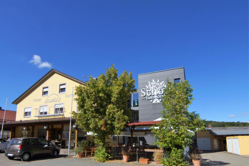 un bâtiment avec une voiture garée devant lui dans l'établissement Landhotel Schöll, à Parsberg