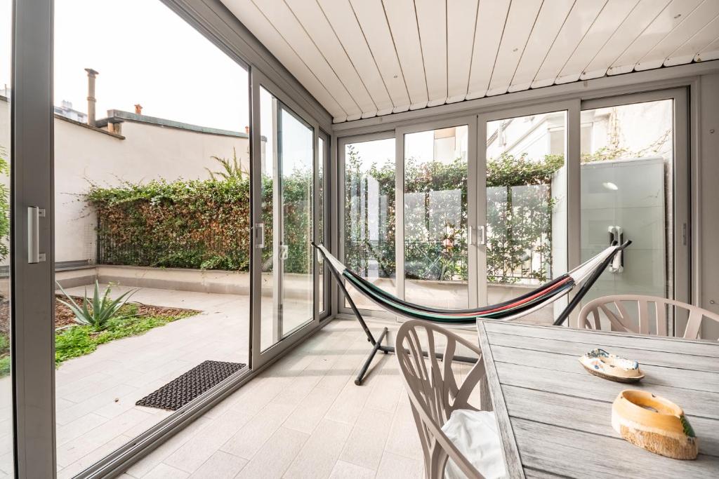 weranda z hamakiem, stołem i krzesłami w obiekcie Renovated APT with Garden & Veranda! w Mediolanie
