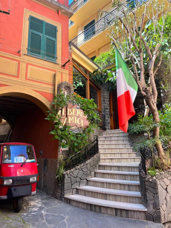 a red car parked in front of a building with a flag at Albergo Degli Amici in Monterosso al Mare