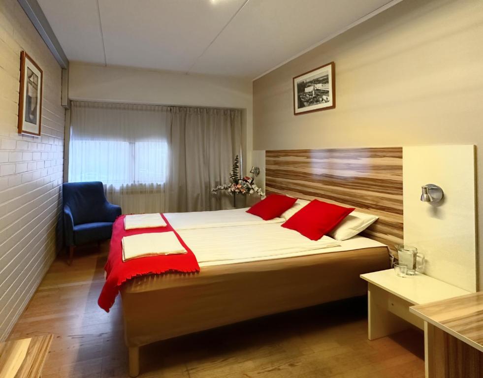 Arkadia Hotel & Hostel في هلسنكي: غرفة نوم بسرير كبير وكرسي ازرق