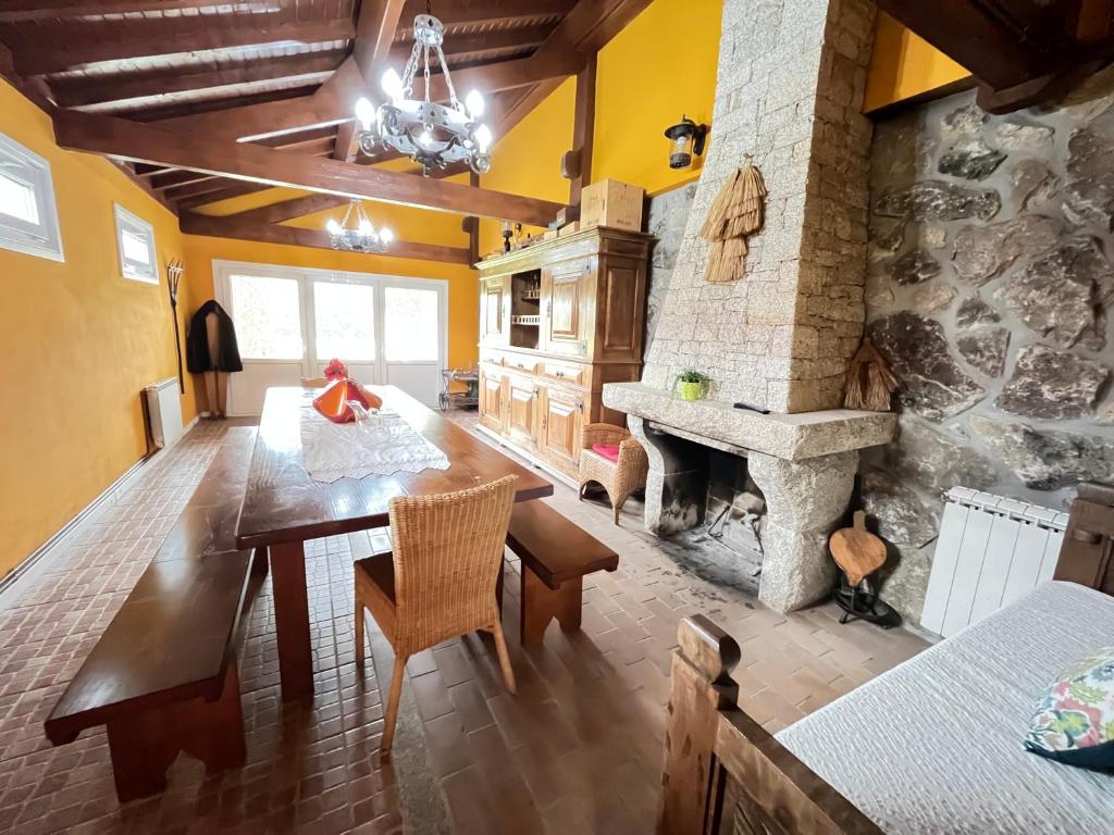 a dining room with a table and a stone fireplace at Casa do Rolo by Trip2Portugal in Montalegre