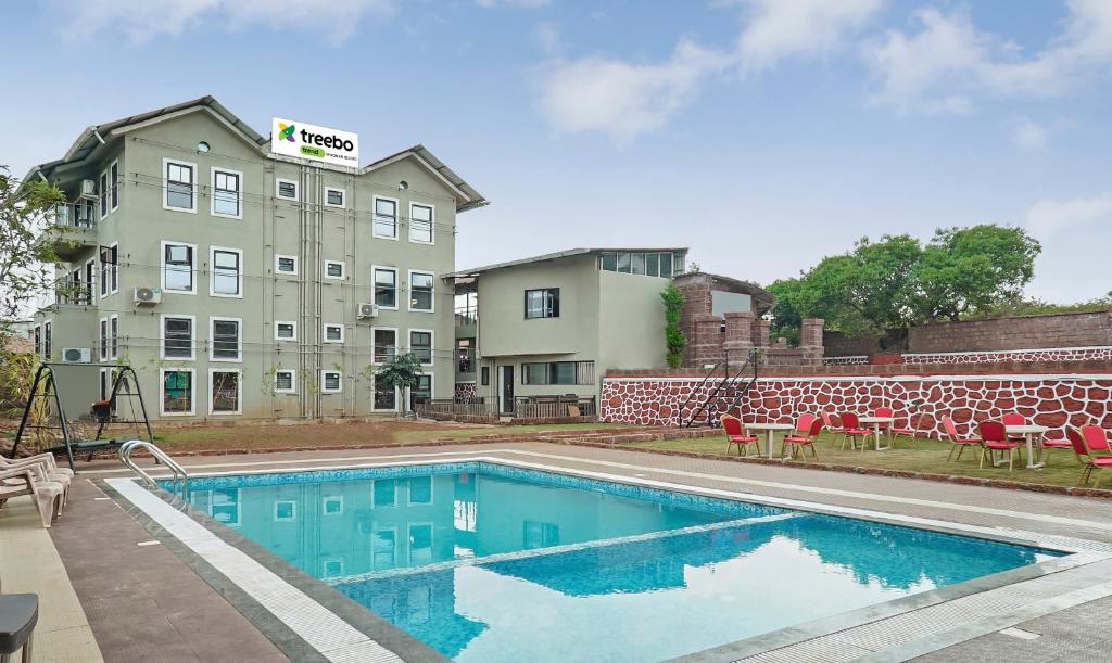 a swimming pool in front of a building at Treebo Trend Vhyomaan Resort in Mahabaleshwar