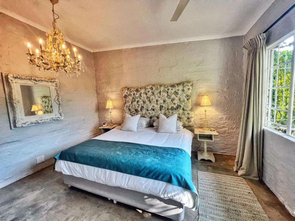 a bedroom with a large bed and a chandelier at Chocolate Orchid in White River